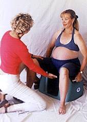 Photo of midwife assisting woman sitting on the Seat